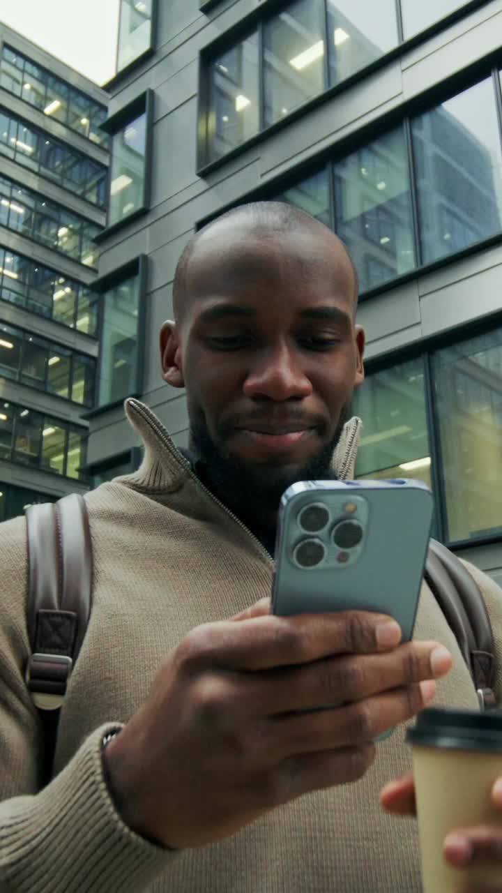 hombre usando un teléfono inteligente mientras bebe café afuera