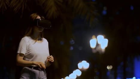 Young-girl-Simulated-virtual-reality-work-in-glasses-in-modern-big-city-at-night-on-my-lanterns-and-beautiful-bokeh-of-passing-cars-and-buildings