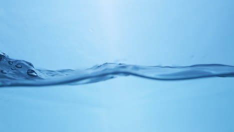 Vista-Macro-De-Dinámica-De-Fluidos-De-Gotas-De-Agua-Dulce-En-Movimiento-Sinfonía-De-La-Naturaleza-Efecto-De-Ondulación-Del-Agua-En-Cámara-Lenta-En-Tono-Azul