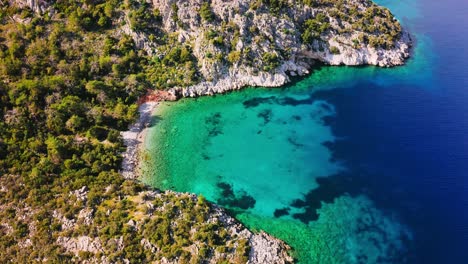 panoramic view of small mediterranean lagoon among steep mountain slopes covered with garrigue vegetation