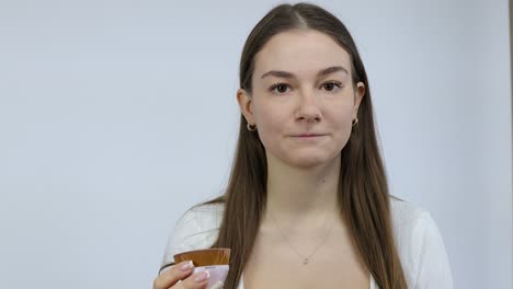 makeup wrong shade color mistake by a young caucasian woman in the morning applying by mistake in front of a white background