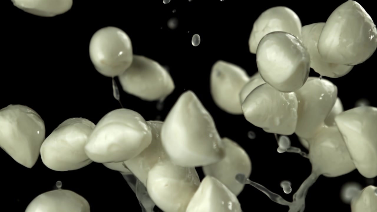Palline di mozzarella fresca che cadono al rallentatore