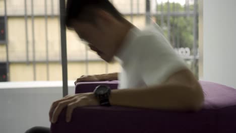 Asian-Man-sitting-down-on-a-purple-chair-for-an-interview-and-answering-questions