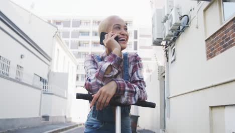 Mixed-race-woman-on-electric-scooter-and-on-a-phone-call