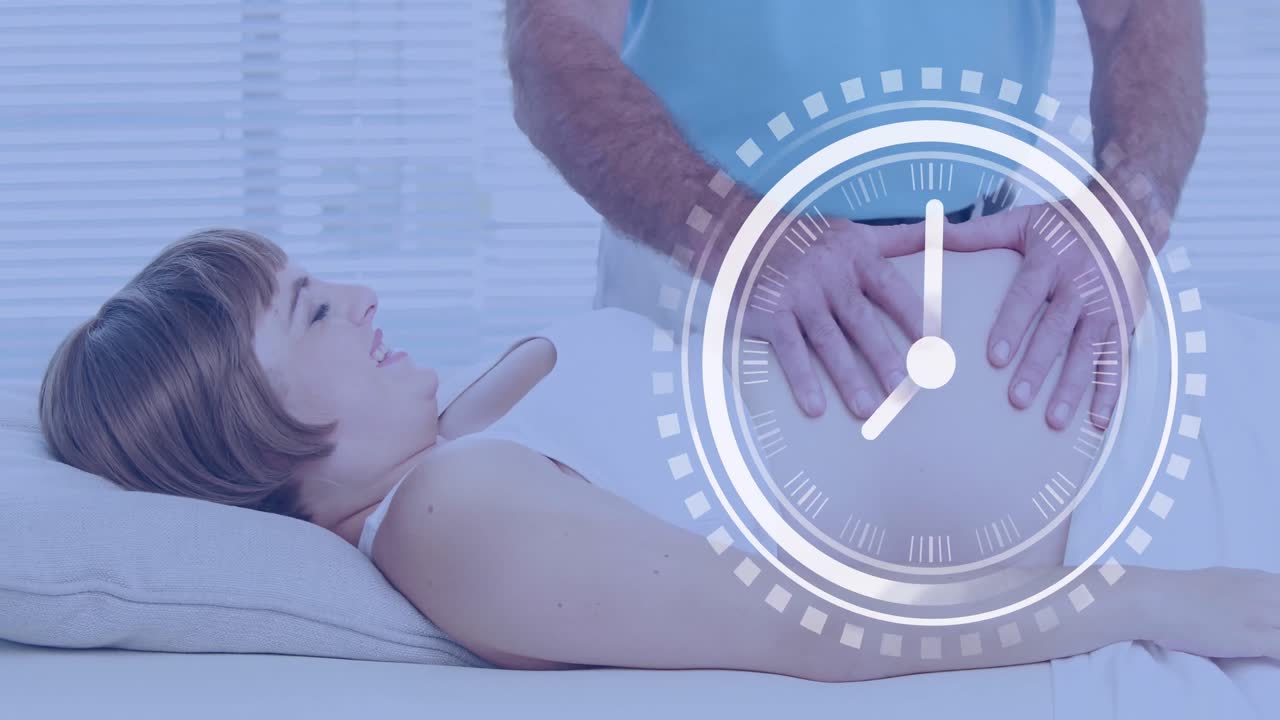 быстро движущиеся часы над счастливой беременной белой женщиной, которой муж массажирует живот