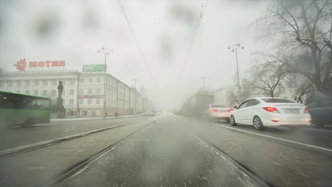 vista de la calle de la ciudad nevada y lluviosa