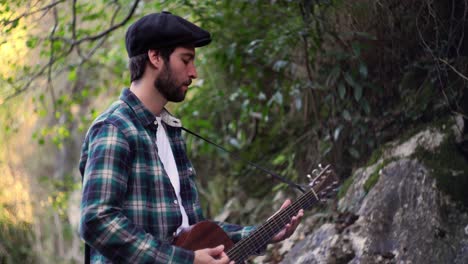 imágenes estáticas con fondo de naturaleza borrosa de un músico inspirador tocando una canción con guitarra acústica