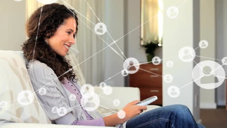 Animation-of-network-of-connected-icons-in-circles-over-happy-biracial-woman-using-smartphone