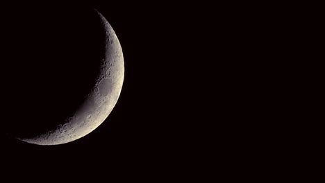 close up of the waning crescent moon with craters visible slowly rotating - night time lapse