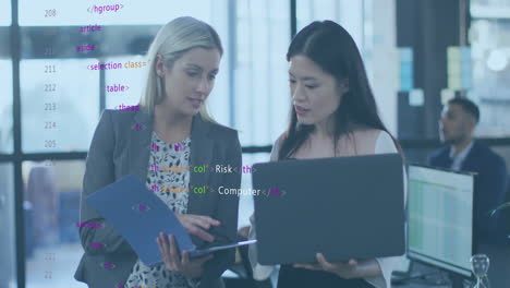 Animation-of-computer-language-over-diverse-female-coworkers-discussing-reports-on-laptop-in-office