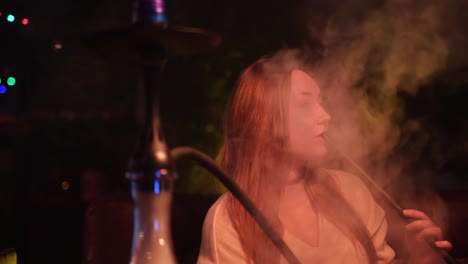 woman smoking hookah at night