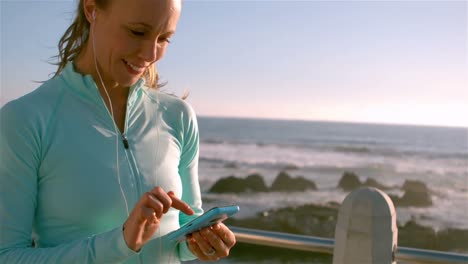 mujer deportiva sonriente en su teléfono inteligente
