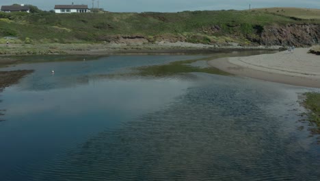 Aerial-low-angle-above-calm-and-reflective-stream-in-summer