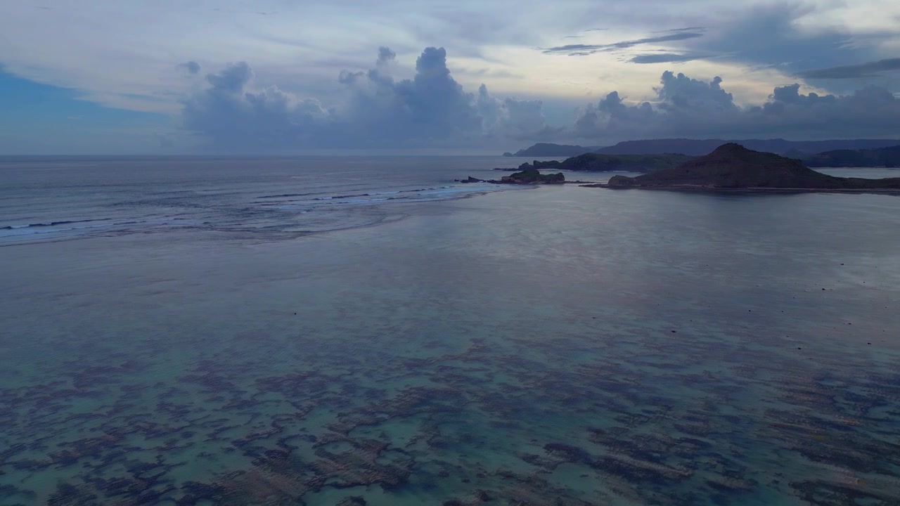 Scogliera verde lussureggiante che si affaccia sull'oceano blu cristallino con piccole onde che si infrangono, suggerendo una destinazione tropicale. Favolosa vista aerea panoramica con drone.
