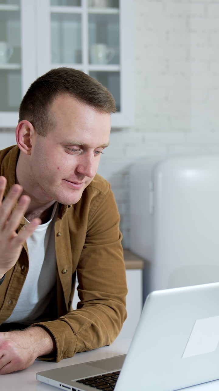 Happy businessman talking on video conference online at home. Male professional explaining project with gestures at remote workplace Vertical video