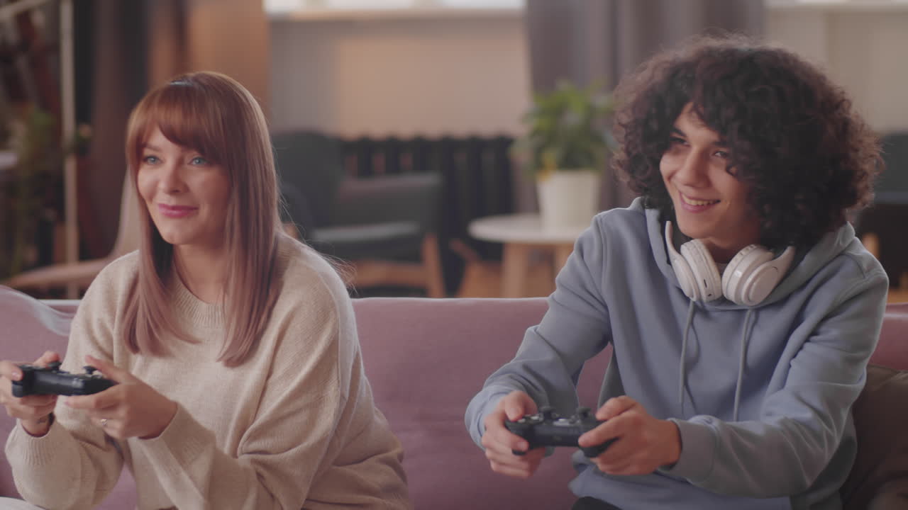 Teenager Playing Game on Console with Mother at Home