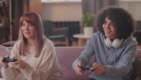 teenager playing game on console with mother at home