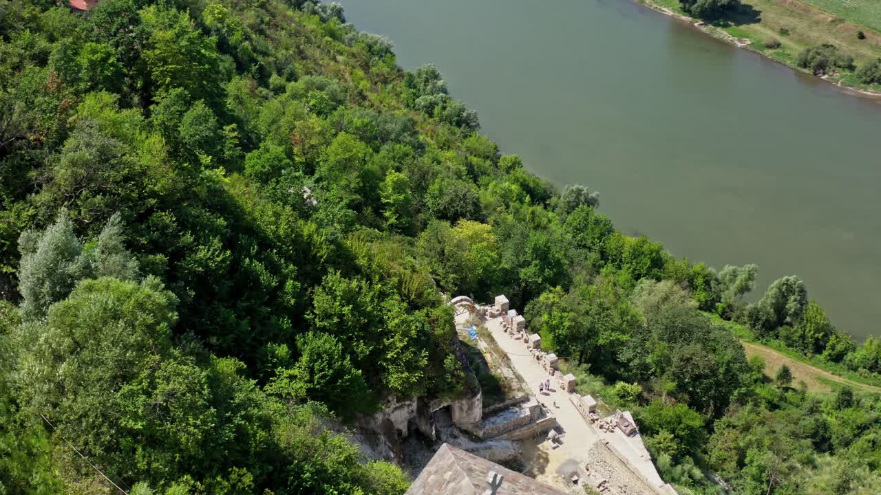 Aerial view on the tower of the castle located on a top of a hill. Beautiful river flows below. Selective focus on video.