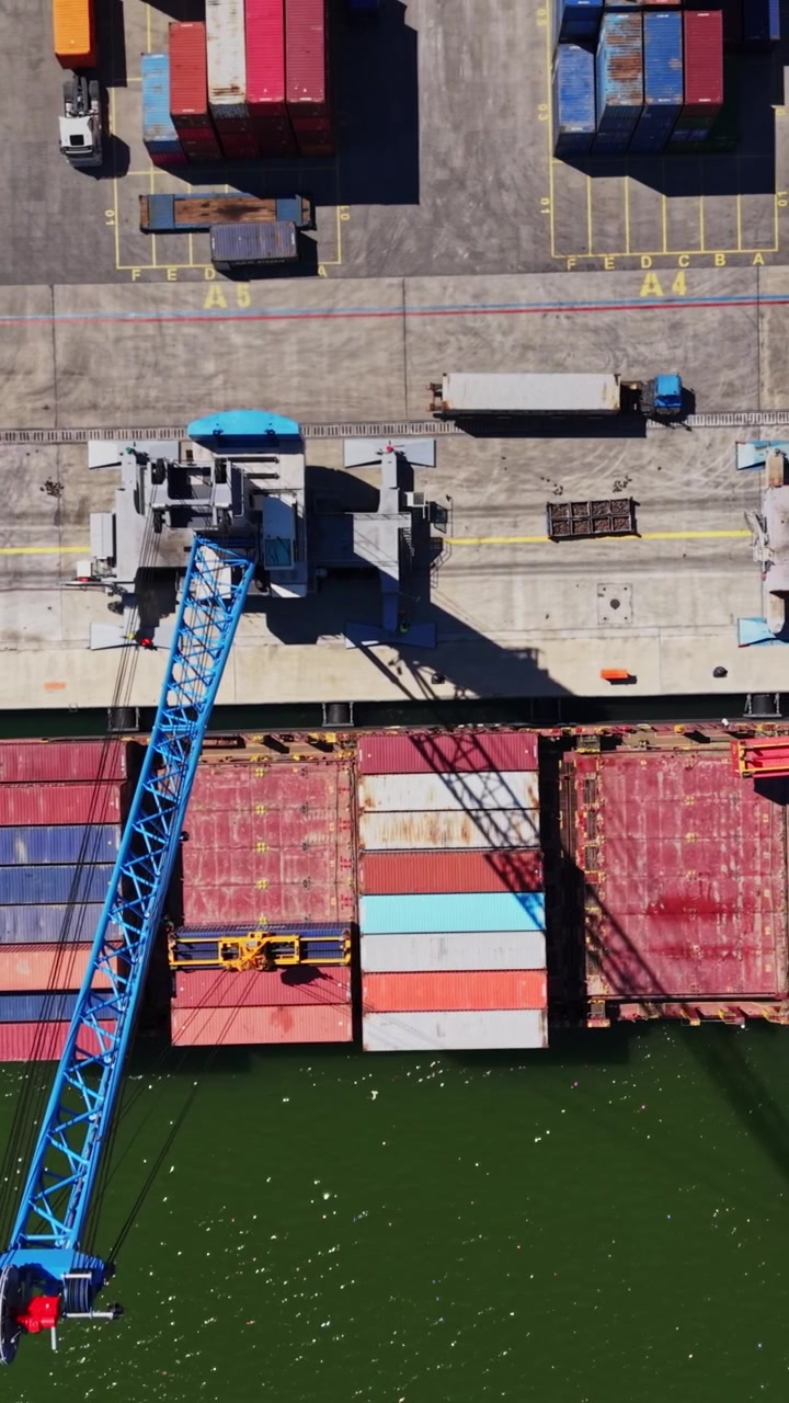 Cargo ship loading at port with cranes in action during daytime