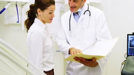 Dentist-discussing-report-with-female-patient