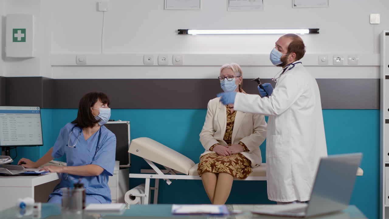 Otologist consulting senior woman using medical otoscope