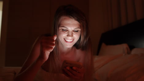 mujer usando el teléfono en la cama por la noche