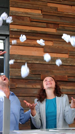 business executives throwing crumpled paper in air