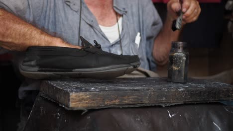 man polishing a black shoe