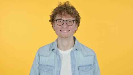 joven pelirrojo sonriente, fondo amarillo
