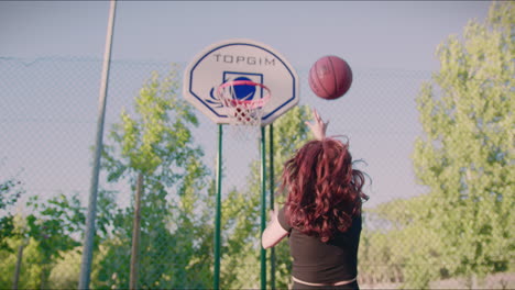 basketball court redhead girl dribbles ball towards hoop and misses