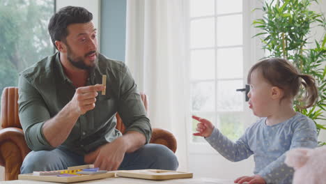 Padre-Con-Síndrome-De-Down,-Hija-Jugando-Con-Letras-De-Madera-En-Casa-Juntos