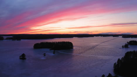 Drone-video-of-an-ice-road-in-beautiful-frozen-lake-by-golden-hour