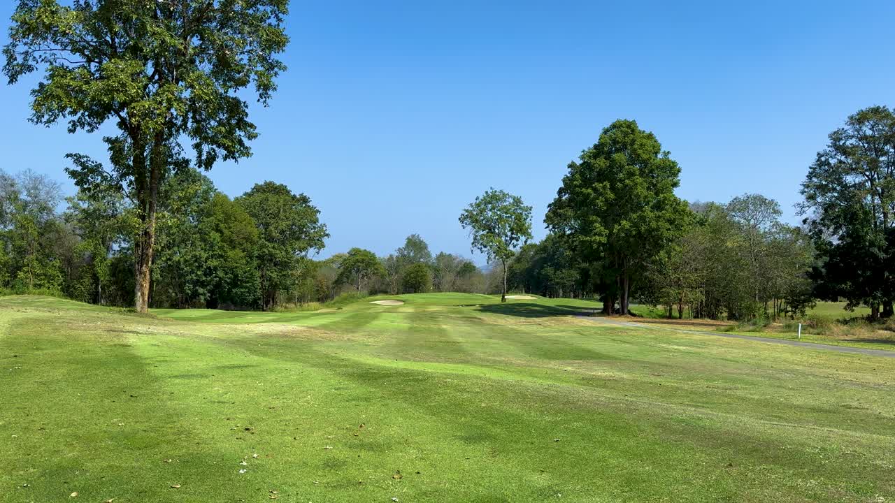 Lush green golf course with clear blue skies