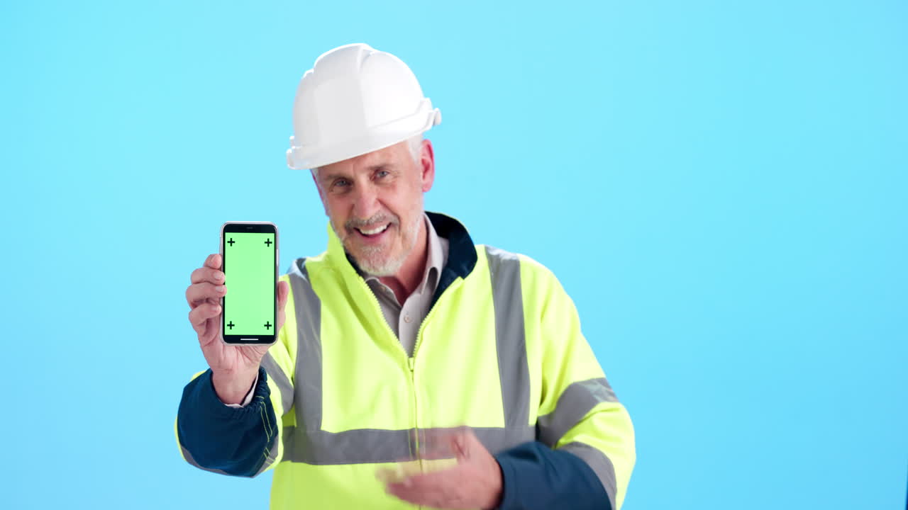 Construction worker showing phone with green screen