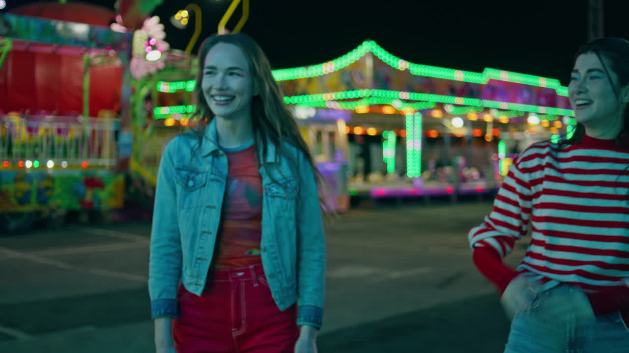 счастливые девушки обнимаются, веселый карнавал, веселые друзья веселятся в развлечениях.