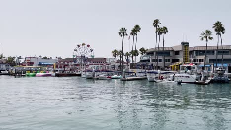 pov from the balboa ferry of small boats and the ferris wheel on the shore of balboa island