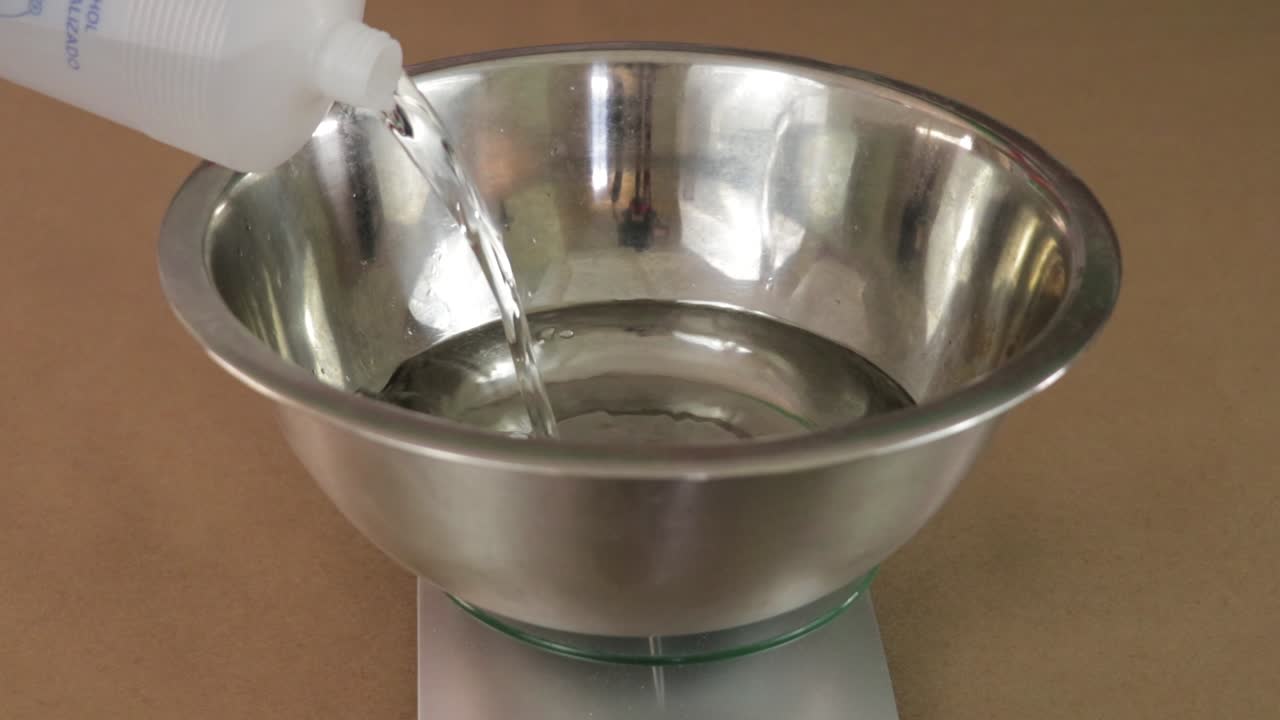 vierta alcohol en un recipiente en una máquina de pesaje