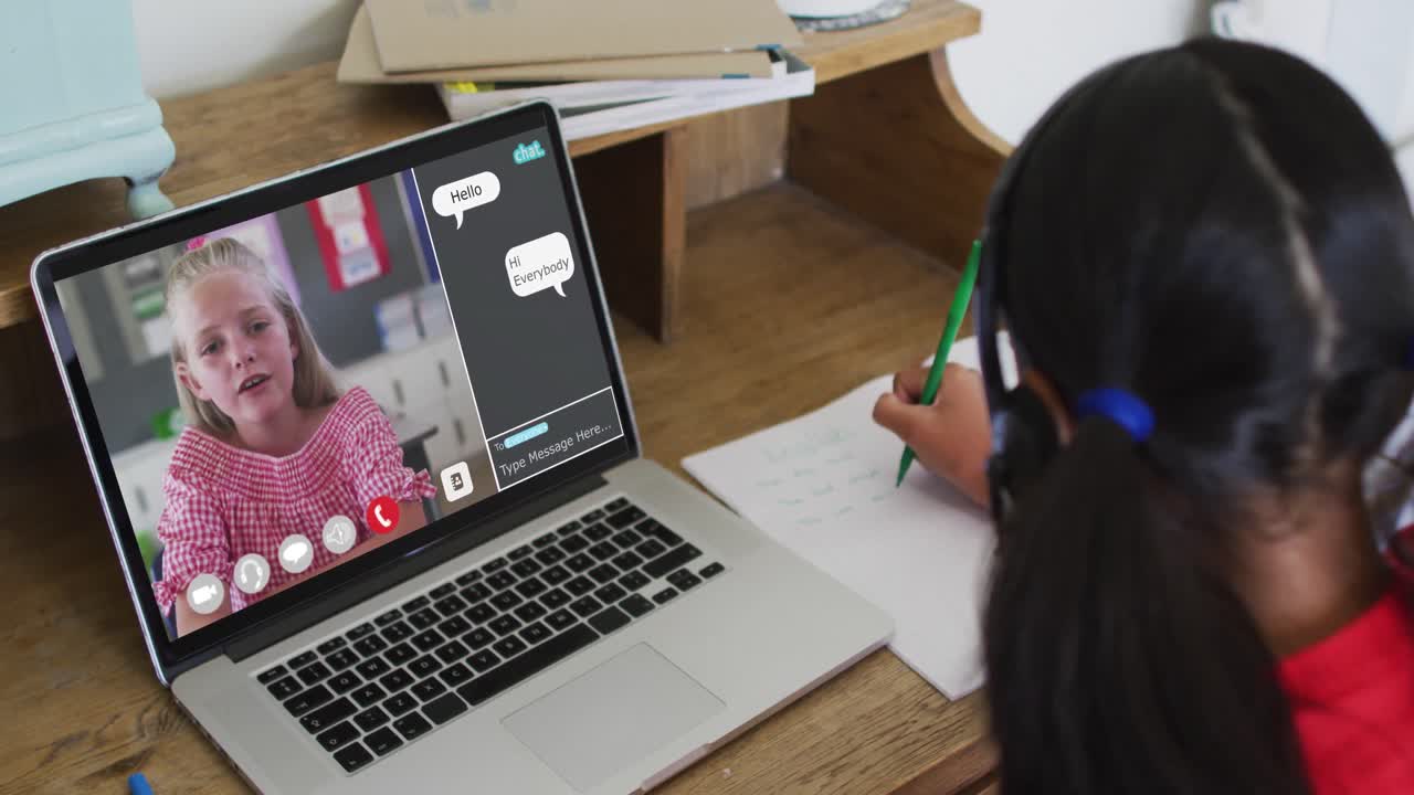 Schoolgirl using laptop for online lesson at home, with her colleague and web chat on screen