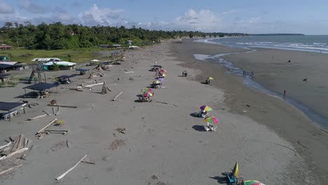personas disfrutando de un día en la playa de la barra en la costa colombiana