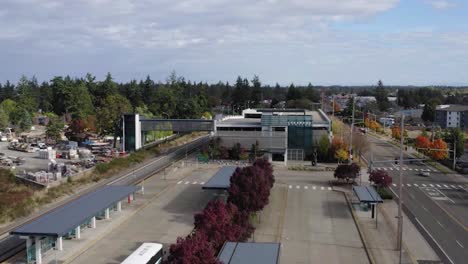 Empty-Parking-Garage-and-Train-Platform-at-Lakewood-Station-along-Pacific-Highway,-Southwest-Lakewood,-Washington,-United-States---aerial-pullback