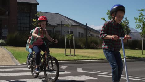 Gruppe-Von-Kindern,-Die-Fahrrad-Und-Roller-Fahren-Und-Die-Straße-überqueren