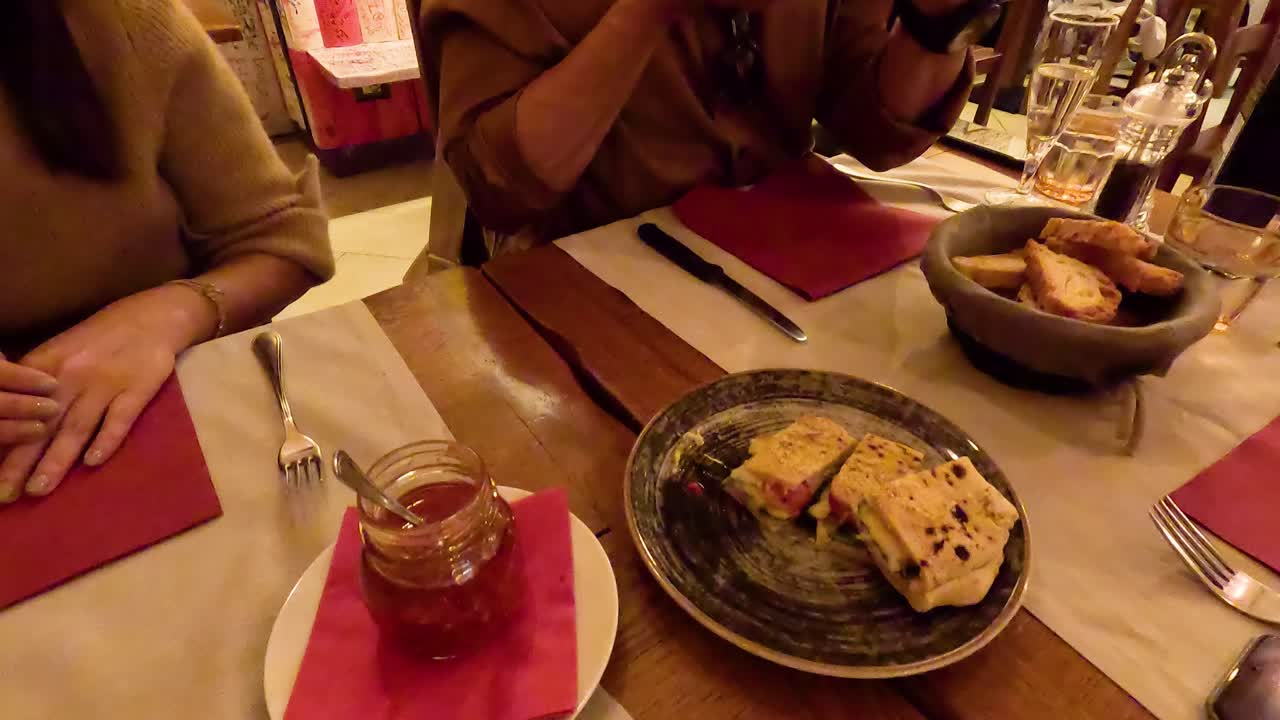 Two people sharing a sandwich at a restaurant