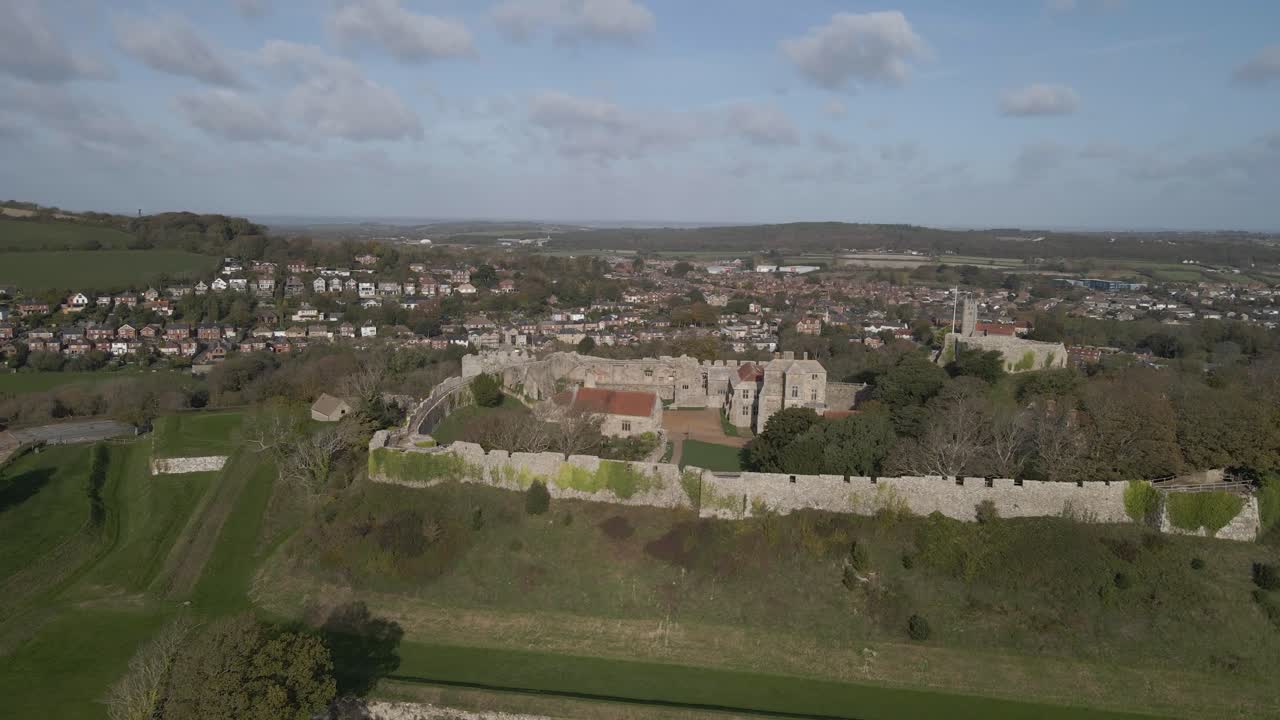 Castle a great fortress which began life as an Anglo-Saxon earthwork defence against Viking raids. Drone rmoving to the left showing the castle, the buildings and the green fields around the castle