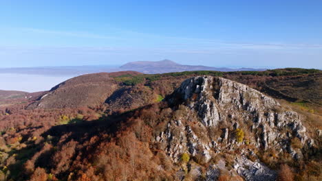 autumn mountain landscape with rocky peak and colorful forests