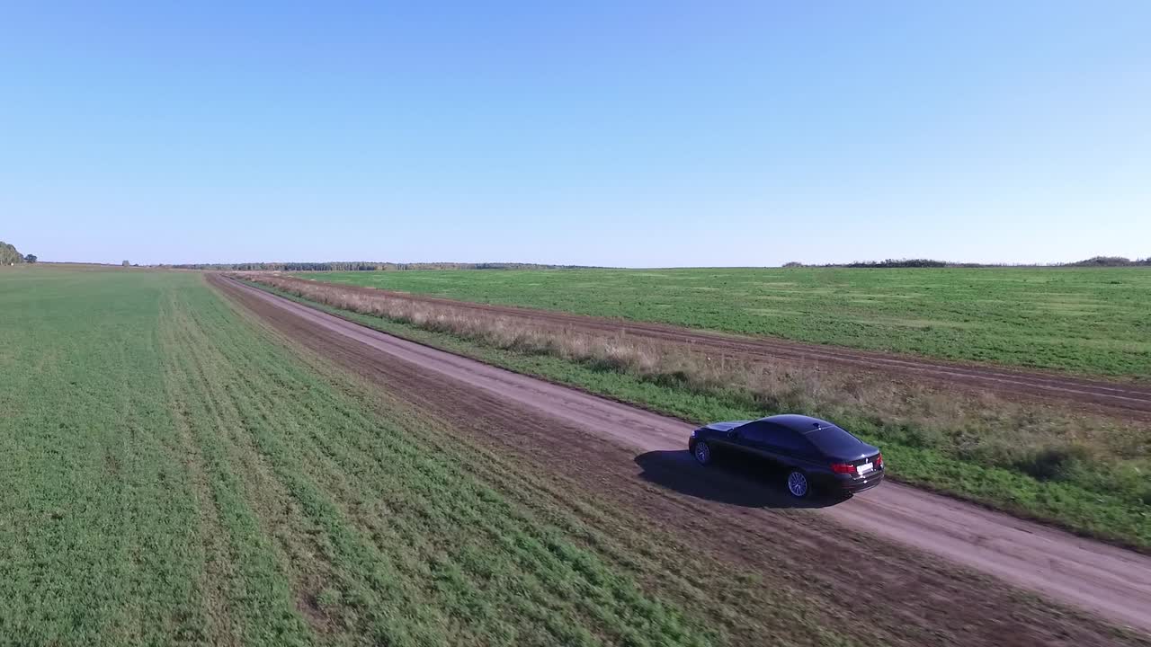Auto su una strada sterrata attraverso i campi