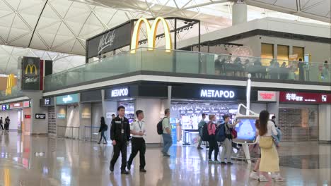hong kong airport terminal: passengers, shops, and mcdonald's