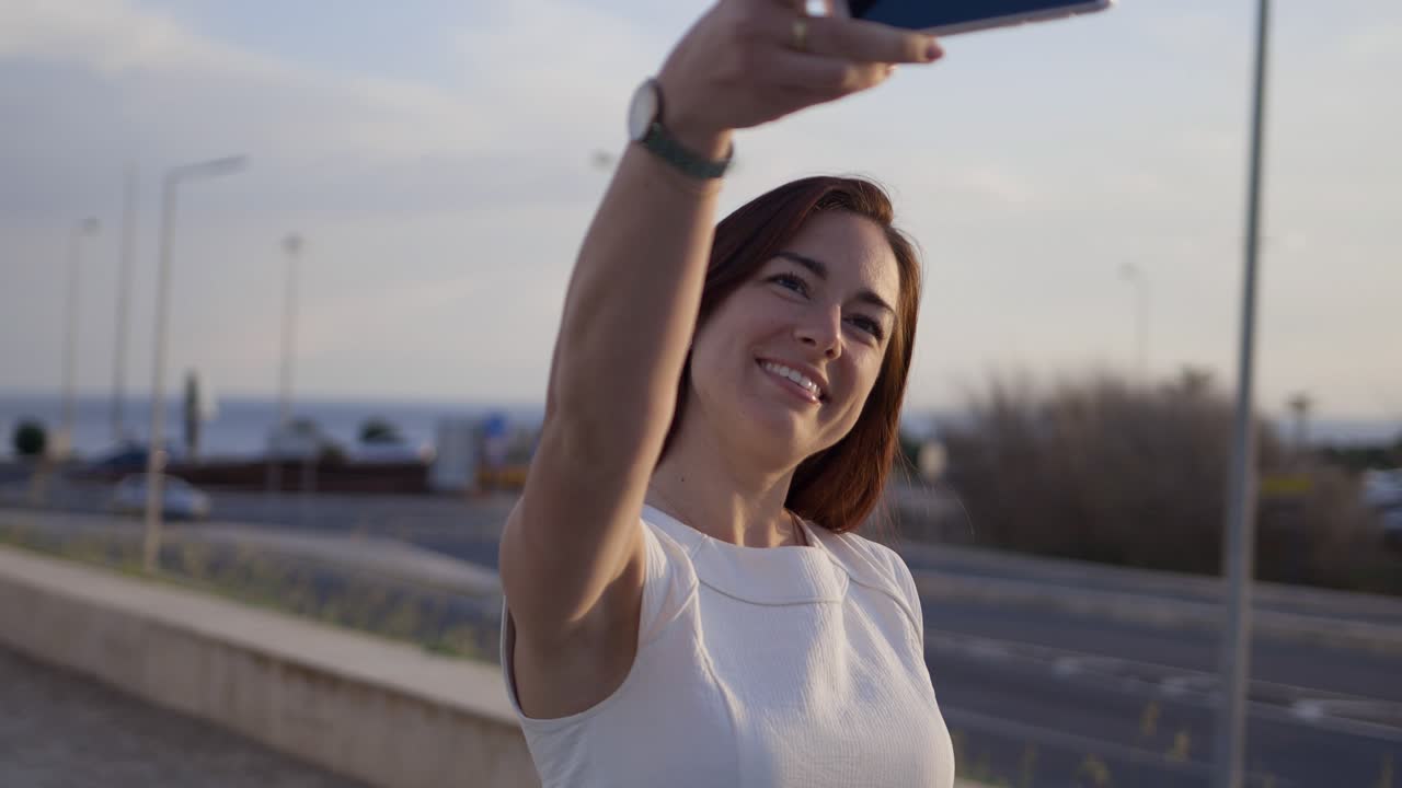 hermosa mujer pelirroja sonriente tomando una selfie con su teléfono inteligente.