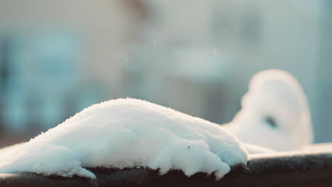 Primer-Plano-Cinematográfico-De-Una-Nieve-En-El-Balcón-Durante-Un-Amanecer-Mientras-Los-Copos-De-Nieve-Caen-Del-Cielo-En-Cámara-Lenta.