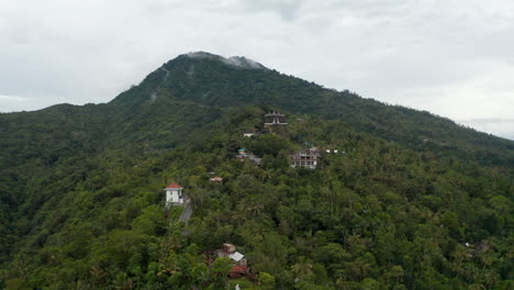 Vista-Aérea-Del-Templo-Hindú-Y-Casas-Rurales-Al-Pie-De-Una-Montaña-En-Bali.-Templo-Pura-Penataran-Agung-Lempuyang-Y-Casas-Residenciales-En-Las-Laderas-De-La-Montaña-Lempuyang