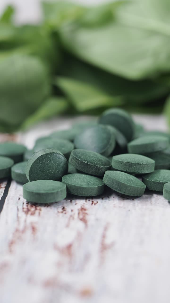 Yeşil Spirulina Hapları ve Taze Yaprakların Yakın Çekimi